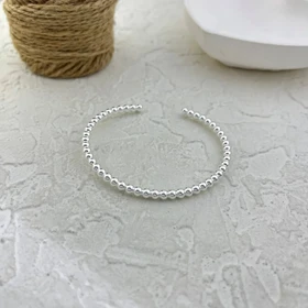 دستبند زنانه بنگل مدل اوربینا طرح گوی‌های نقره‌ای مینیمال