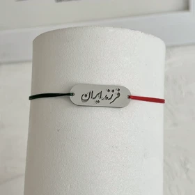 دستبند فرزند ایران استیل رنگ ثابت با بند نخی (نخ دو رنگ سبز قرمز)