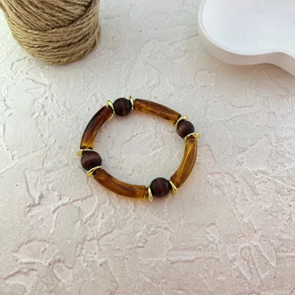 دستبند زنانه بنگل رزینی و چوبی چندتکه مدل لورا عسلی‑طلایی