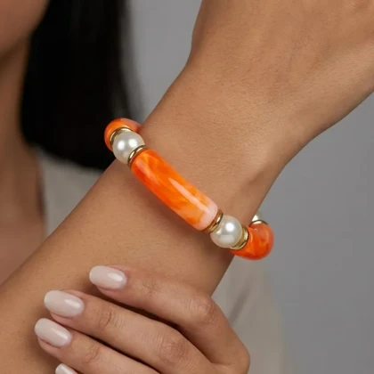 دستبند زنانه بنگل رزینی و مرواریدی چندتکه مدل پرلورا نارنجی‑طلایی