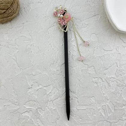 کانزاشی مو زنانه چوبی با طرح گل‌های صورتی و آویز ظریف مدل رزلیا