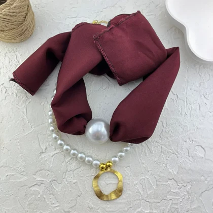 گردنبند زنانه مدل پرلا واین گلد طرح مروارید لوکس با پارچه زرشکی و آویز طلایی انتزاعی