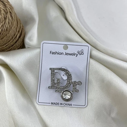 گل سینه زنانه مدل درخشان طرح حروف Dior نگین‌دار
