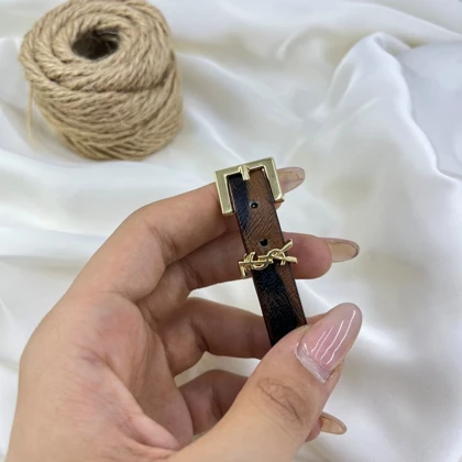 دستبند زنانه چرمی مدل آرا طرح پلنگی با سگک طلایی و آویز لوگو