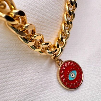 دستبند کارتیر استیل طرح «چشم‌نظر خورشیدی» | زنجیر کوبایی طلایی با پلاک میناکاری قرمز