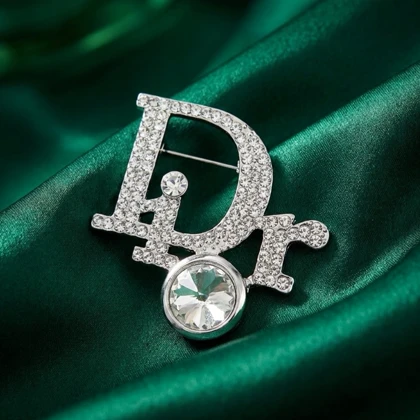 گل سینه زنانه مدل درخشان طرح حروف Dior نگین‌دار