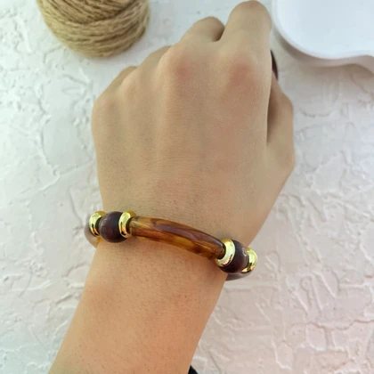 دستبند زنانه بنگل رزینی و چوبی چندتکه مدل لورا عسلی‑طلایی