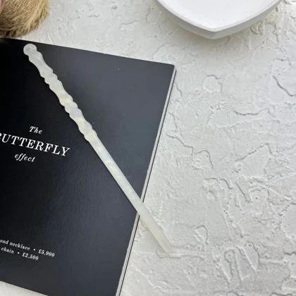 کانزاشی مو زنانه رزینی شفاف شیری با بدنه موج‌دار ظریف و طراحی کشیده