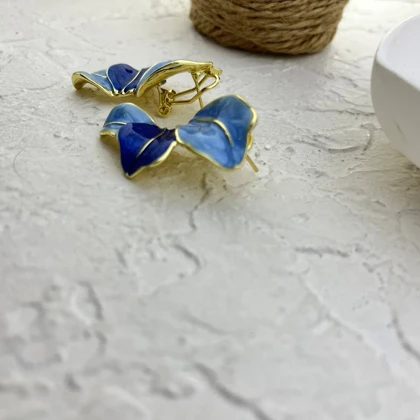 گوشواره زنانه طرح گلبرگ مدل نیلا با میناکاری آبی و جزئیات طلایی