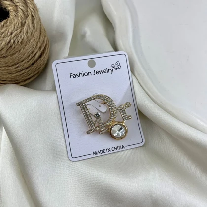 گل سینه زنانه مدل درخشان طرح Dior نگین‌دار طلایی