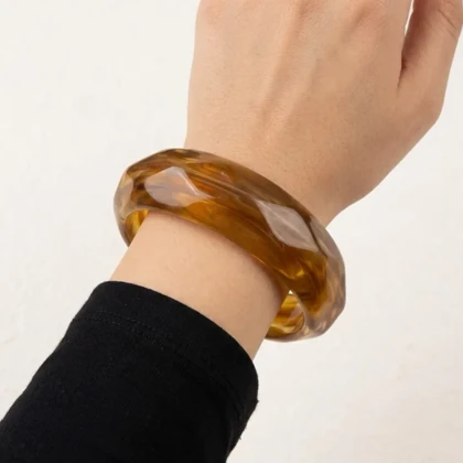 دستبند زنانه بنگل رزینی مدل امبریا کهربایی موج‌دار