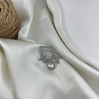 گل سینه زنانه مدل درخشان طرح حروف Dior نگین‌دار
