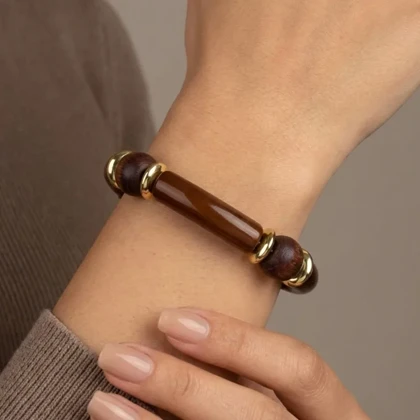 دستبند زنانه بنگل با بافت رزینی و مهره چوبی با فینیش طلایی مدل وودلیرا