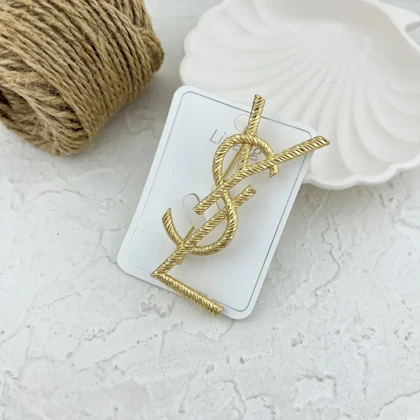 گل سینه طرح YSL طلایی، استایلی بی‌نظیر برای بانوان خوش سلیقه