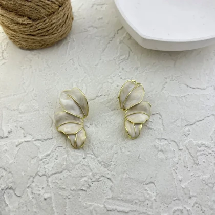 گوشواره زنانه طرح گلبرگ مدل النا با میناکاری سفید و جزئیات طلایی