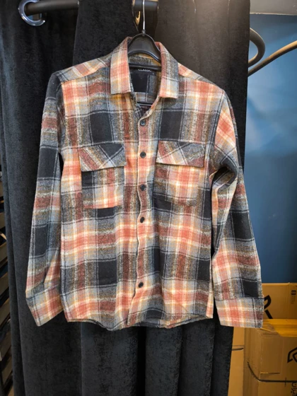 پیراهن پشمی چهارخونه با پارچه برس‌خورده نرم با ترکیب رنگ نارنجی سوخته، مشکی و بژ با ته‌مایه‌های قهوه‌ای خاکی