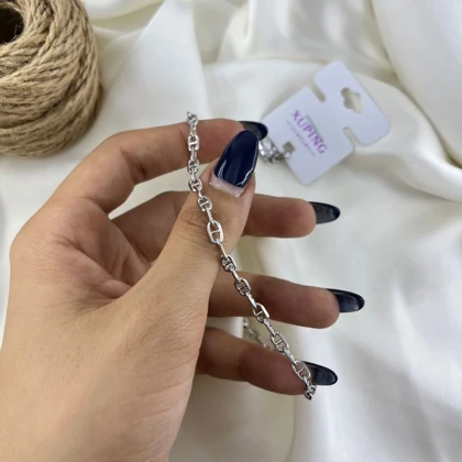 پابند زنانه ژوپینگ مدل آوین طرح لنگری رنگ نقره‌ای با آویز قلب و زنگوله