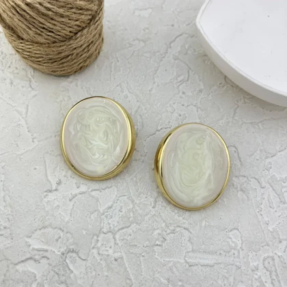 گوشواره زنانه مدل آیووریا اووال طرح میناکاری سفید صدفی با فریم طلایی