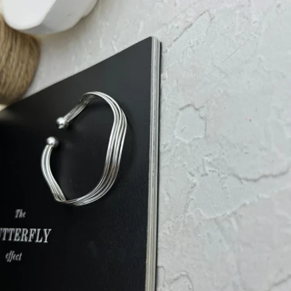 دستبند زنانه بنگل مدل فلوول طرح جریان موجی ظریف نقره‌ای