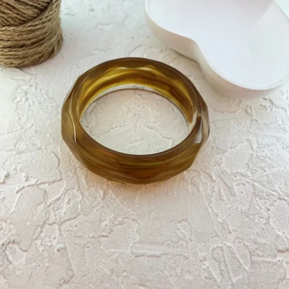 دستبند زنانه بنگل رزینی مدل امبریا کهربایی موج‌دار