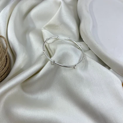 دستبند زنانه بنگل مینیمال مدل گویین طرح توپی نقره‌ای